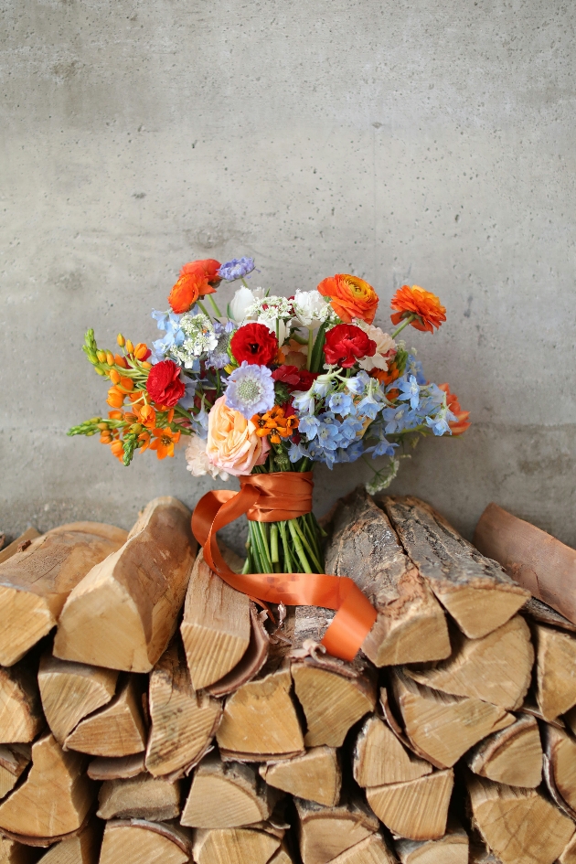 wildflower bouquet sat on wood pile