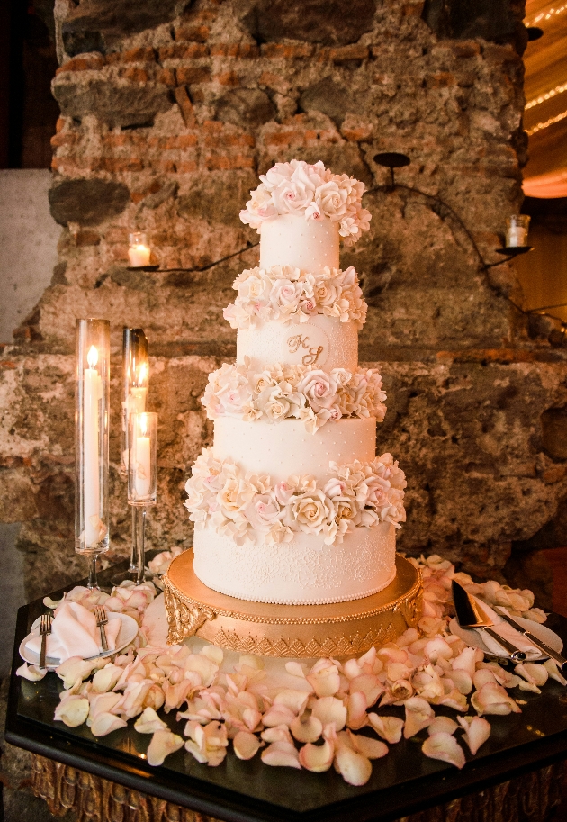 monogramed wedding cake decorated with roses. 