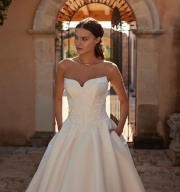 bride in white strapless wedding dress with hands in pockets