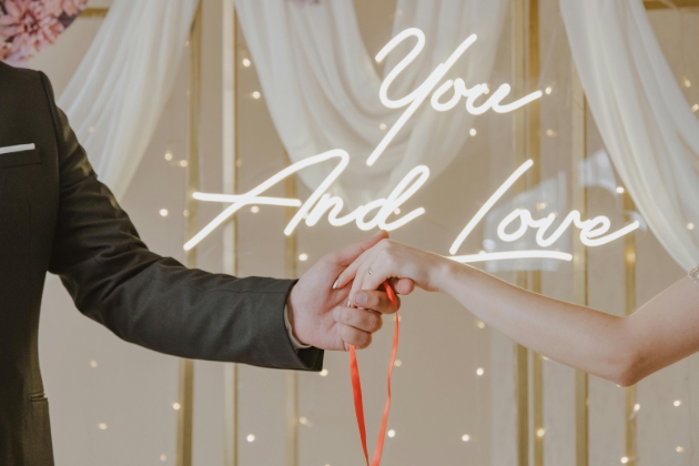 wedding handfasting with you and love neon sign in background