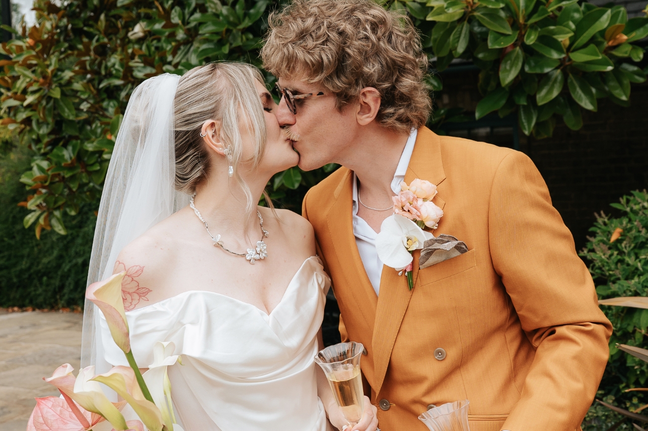 man and woman on their wedding day sharing a kiss 