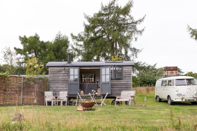 outside shot of shepherds hut with campervan parked on the side