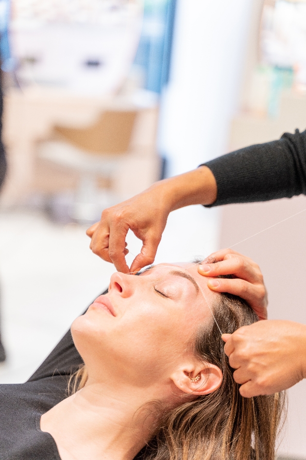 woman having her eyebrows threaded