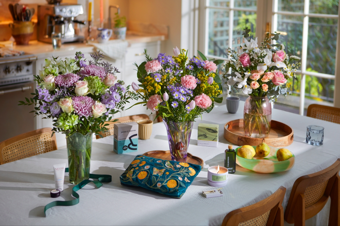 three floral bouquets in vases in a kitchen 