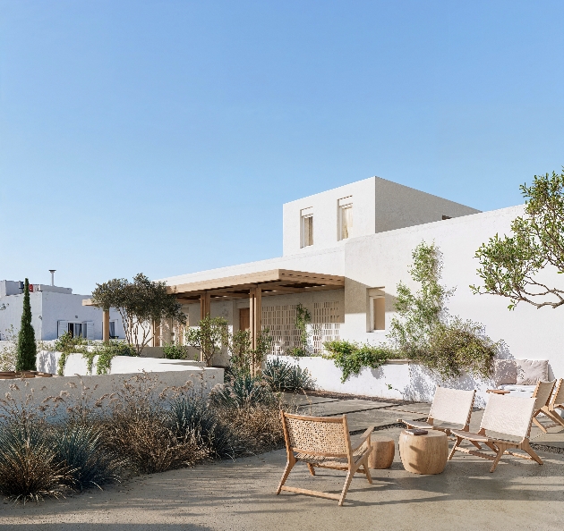 A white building surrounded by plants